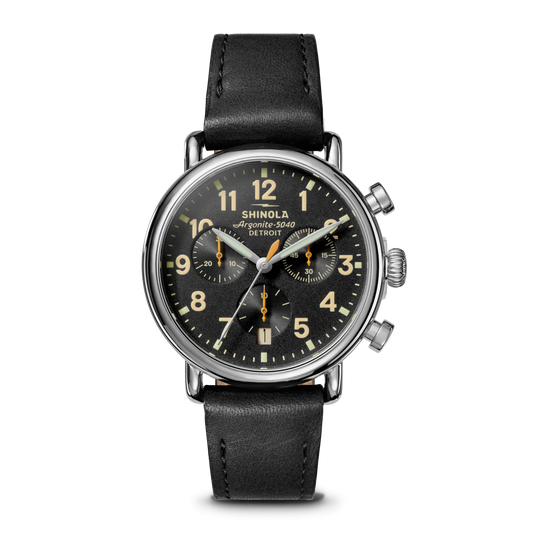 Shinola watch with black leather strap and black dial on a white background