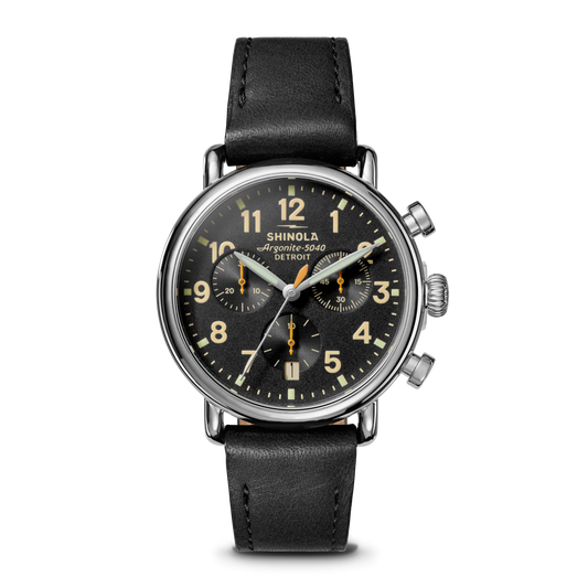 Shinola watch with black leather strap and black dial on a white background